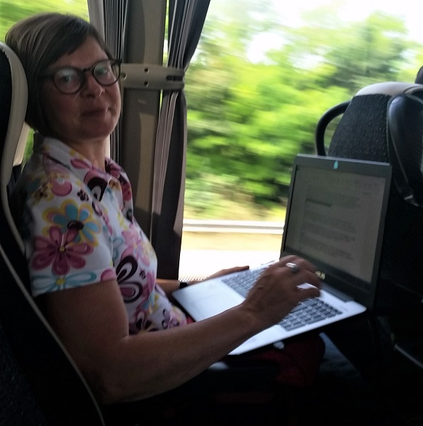 Frau arbeitet im Bus an ihrem Laptop