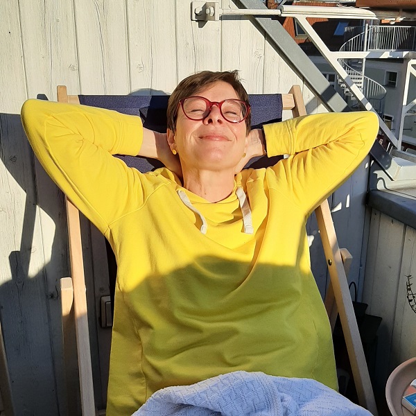 Frau in gelbem Pulli genießt die Sonne