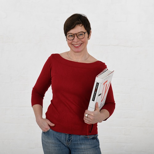Frau im roten Pulli hält ein Typografie-Buch in der Hand