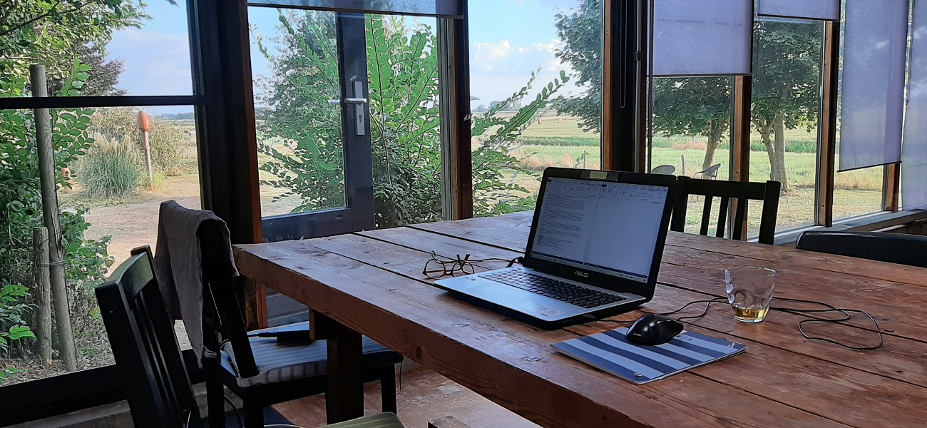 Arbeitsplatz mit Laptop mit Blick in die Landschaft