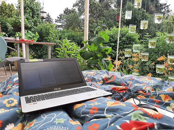 Bett im Garten mit einem Laptop