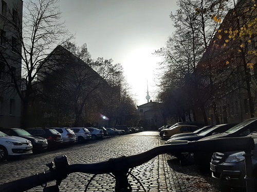 Straße in tiefstehendem Licht im November mit Fernsehturm im Hintergrund 