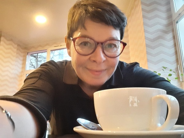 Frau sitzt vor Kaffeetasse