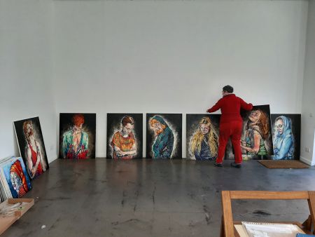 Frau sortiert Gemälde in einer Galerie