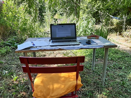 Schreibtisch mit Laptop im Garten