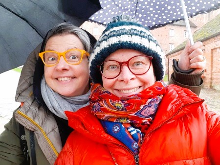 Selfie von zwei Frauen mit Regenschirmen