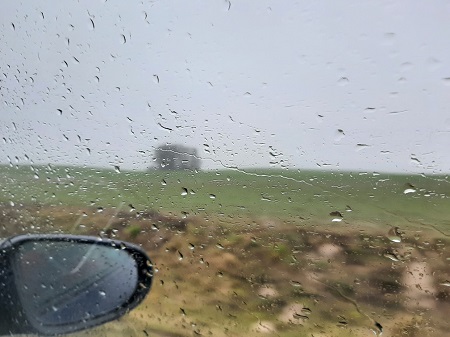 Blick aus dem Seitenfenster vom Auto in triste Regenlandschaft